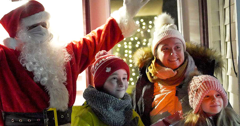 Famille immigrante avec le père Noël lors d'une activité de Noël dans les Communauté francophone accueillantes